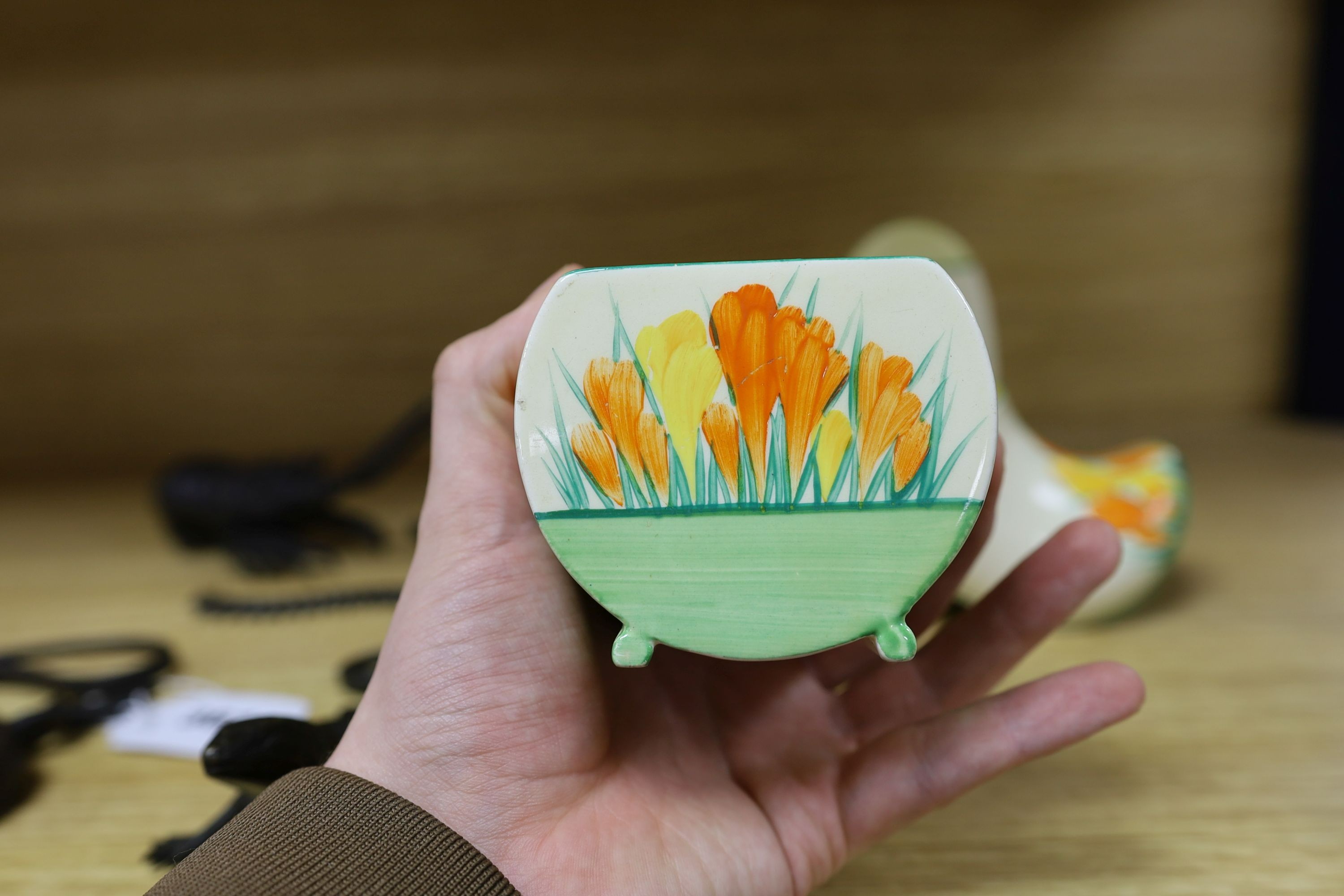 A Clarice Cliff sungleam crocus jam pot and cover, a sugar shaker and a Dutch clog ornament (3), jam pot and cover 10 cms high